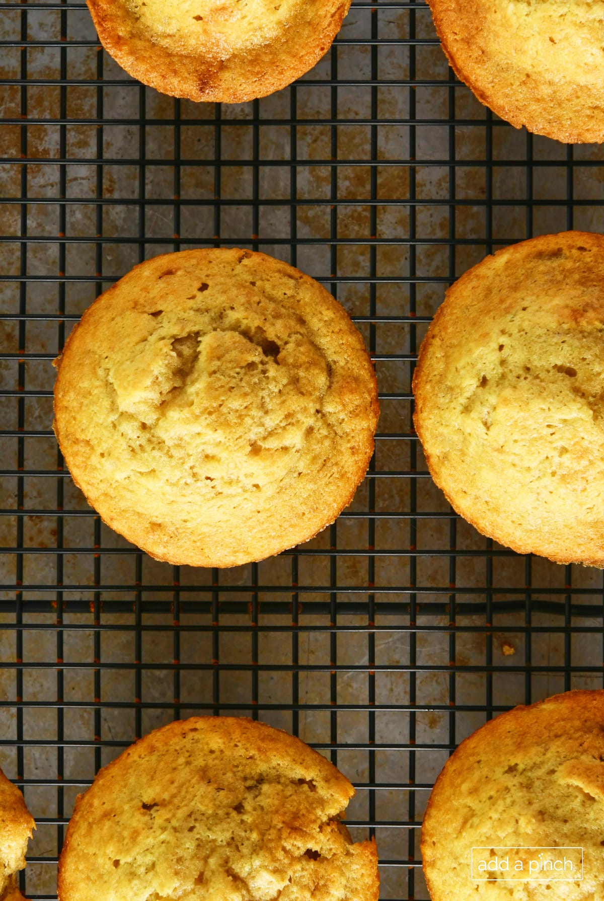 Banana bread muffins cooling on a wire rack.