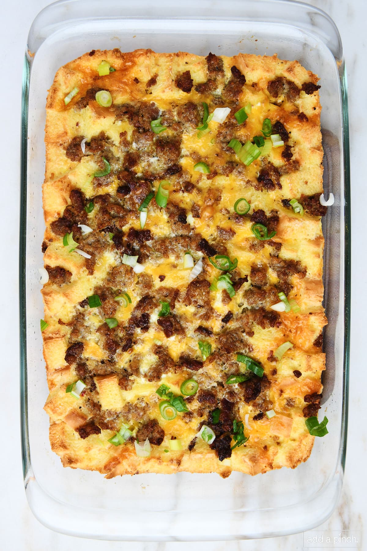 Baked breakfast casserole topped with sliced green onions ready to serve. 