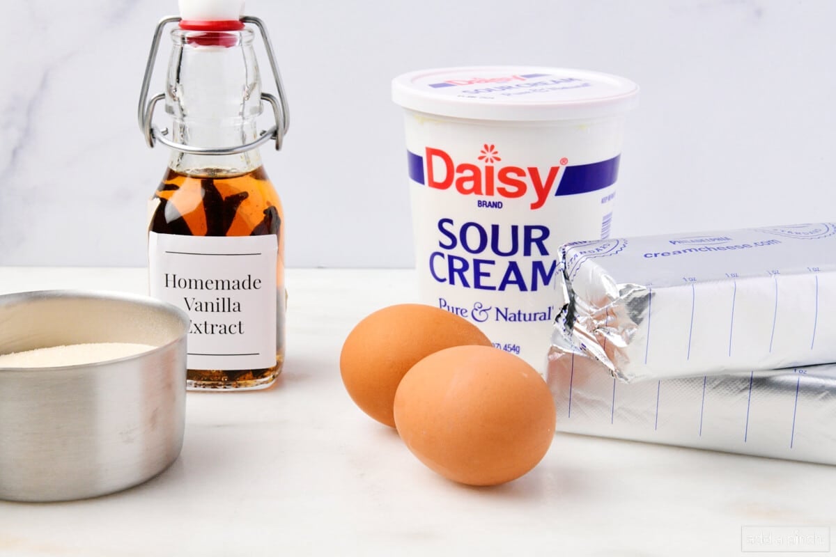 Ingredients used to make cheesecake pie on a marble counter.