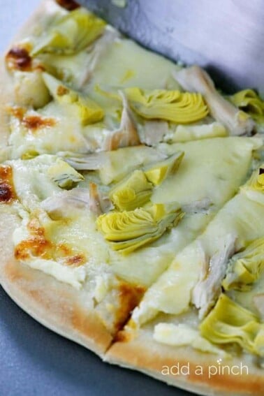 Chicken Artichoke Pizza made with homemade pizza crust, cheese, chicken and artichoke hearts makes a pizza recipe everyone loves! // addapinch.com