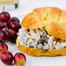 Chicken Salad on a croissant surrounded by red grapes // addapinch.com