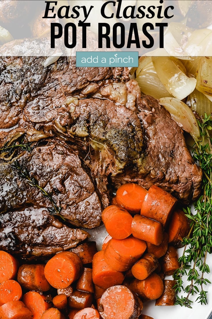 Pot Roast on serving platter with carrots, onions, potatoes and herbs - with text - addapinch.com