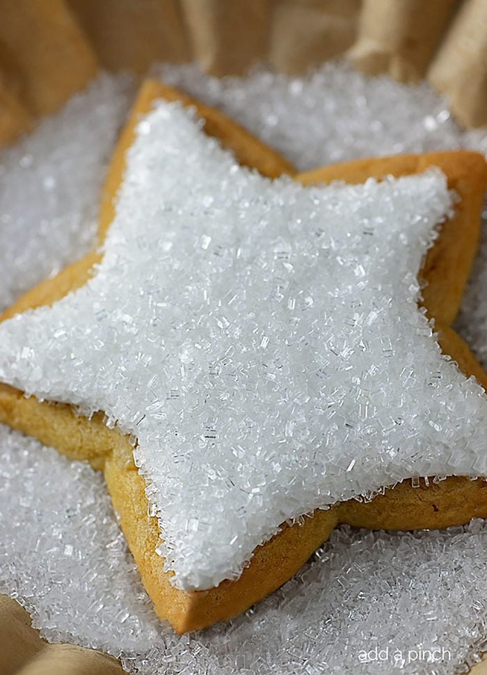 Star shaped sugar cookie decorated with white icing and clear crystals. 