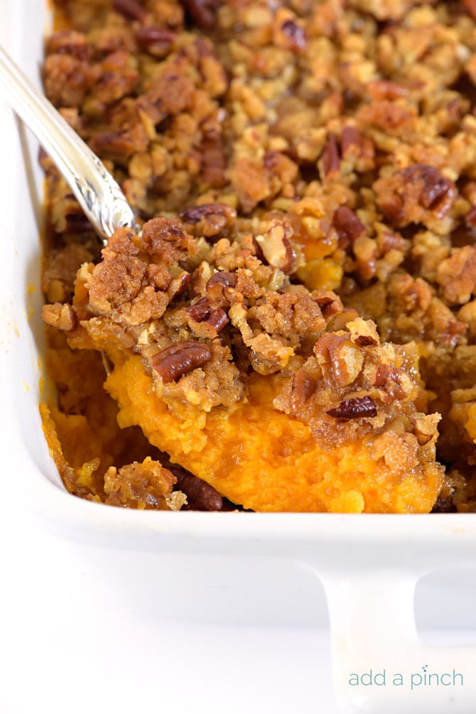 Sweet Potato Casserole with pecan streusel topping in white baking dish 