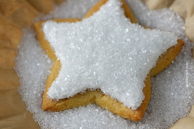 Star shaped cookie decorated with white icing and crystals. 