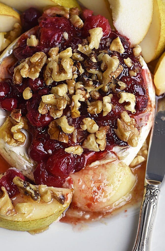 Warm Brie with Honeyed Fruit Compote makes a beautiful, quick and easy appetizer. Made with a honeyed cranberry walnut fruit compote, this warm brie recipe is festive for the holidays! // addapinch.com